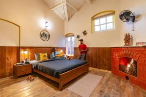 a bedroom with a bed and a brick fireplace at The Hosteller Ooty in Ooty