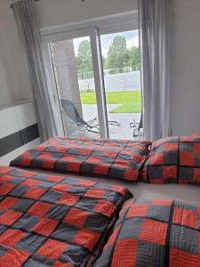 ein Schlafzimmer mit zwei Betten und einem großen Fenster in der Unterkunft Ferienhaus mit privatem Seezugang, Sauna, Strand, Wassersport, Ruderboot, Stand Upp in Barßel