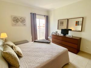een slaapkamer met een bed, een dressoir en een raam bij Apartamento T1 Flamingo - Portimão - 1,5 km da Praia in Portimão