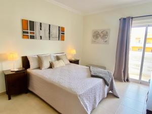 una camera con un grande letto e una finestra di Apartamento T1 Flamingo - Portimão - 1,5 km da Praia a Portimão