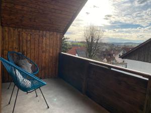 a blue chair on a balcony with a view at Ferienwohnung Fuchs in Himmelkron