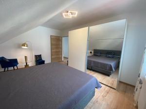 um quarto com uma cama, um sofá e um espelho em Ferienwohnung Fuchs em Himmelkron