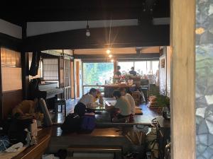 three people sitting at a table in a room at Guesthouse Soranoie in Gero