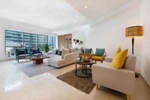 a living room with white furniture and a large window at Maison Privee - Stunning 3-Floor Villa with Kids Room & Rooftop Terrace over Dubai Marina in Dubai