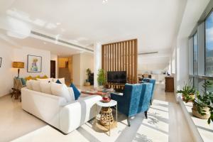 a living room with a white couch and blue chairs at Maison Privee - Stunning 3-Floor Villa with Kids Room & Rooftop Terrace over Dubai Marina in Dubai +31 photos