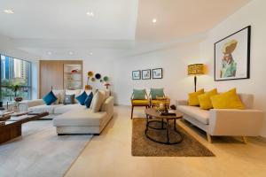a living room with white furniture and yellow pillows at Maison Privee - Stunning 3-Floor Villa with Kids Room & Rooftop Terrace over Dubai Marina in Dubai