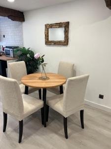 a wooden table with chairs and a vase of flowers on it at Talako-Etxea in Bermeo +1 photo