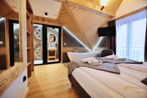 a bedroom with a large bed and a bath tub at Willa Palider in Zakopane