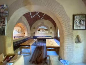 a dining room with tables and a brick wall at Mountain Camp Ali Khaled in Siwa