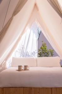 Un dormitorio con una cama blanca con dos velas. en wecamp Cala Montgó, en L'Escala