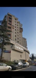 KoTa grey في Karaburma: مبنى كبير فيه سيارات تقف امامه