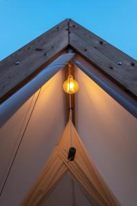 a light hanging from the roof of a tent at wecamp Cala Montgó in L'Escala
