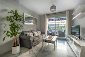 un salon avec un canapé et une plante dans l'établissement Apartamento Las Terrazas ll, à Marbella