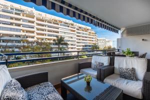 a balcony with chairs and a table and a large building at Apartamento Las Terrazas ll in Marbella