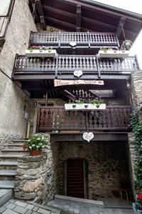un bâtiment en pierre avec des escaliers et des balcons avec des plantes dans l'établissement Maison La Bagne, à Aoste