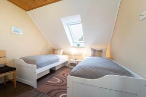 2 Betten in einem kleinen Zimmer mit Fenster in der Unterkunft Ferienwohnpark Amselweg Ferienhaus Bode in Kellenhusen