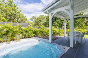 une terrasse avec une piscine et une pergola dans l'établissement Villa Plumbago, à Sainte-Anne