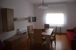 a dining room with a table and a red couch at Allotjament Casa M Cinta in Deltebre