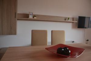 a red plate on top of a wooden table at Allotjament Casa M Cinta in Deltebre