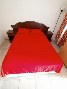 a bed with a red bedspread on it in a room at Apt S4, Park View Terrace- Cozy Convenience! in Crown Point