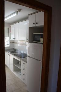 een keuken met een witte koelkast en een magnetron bij Apartamentos Benimar - SABESA in Benidorm