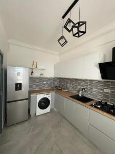 cocina con lavadora y lavavajillas en City View Apartment, en Constanţa
