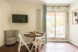 een eetkamer met een tafel en stoelen en een raam bij Appartement proche Champs Elysées in Parijs