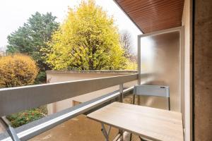 een balkon met een houten tafel en een koelkast bij Appartement proche Champs Elysées in Parijs