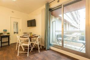 a dining room with a table and a large window at Appartement proche Champs Elysées in Paris