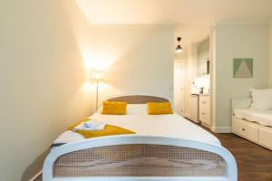 a bedroom with a large white bed with yellow pillows at Appartement proche Champs Elysées in Paris