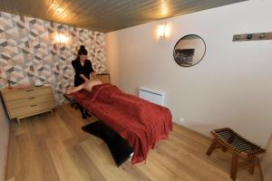 a woman standing next to a bed in a room at Bulle Ecureuil in Quarré-les-Tombes