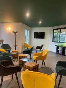 a living room with chairs and tables and a tv at Kyriad Saint Fargeau Ponthierry - Apollonia in Saint-Fargeau-Ponthierry