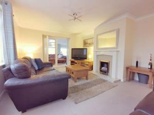 a living room with a couch and a fireplace at Gilfach-3 Bed-Dog Friendly-Detached Bungalow in Trearddur