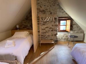 - une chambre mansardée avec 2 lits et une fenêtre dans l'établissement Ferme de Soulan, gîte de charme, à Saint-Lary-Soulan