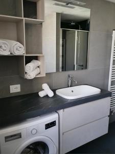 een badkamer met een wasmachine en een wastafel bij Innesti Rooms&Apartments in Pergine Valsugana