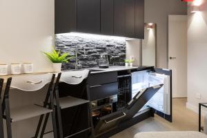 a kitchen with black cabinets and a counter with stools at Special DHome in Milan