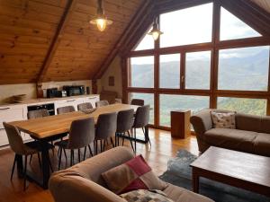 sala de estar con mesa, sillas y ventanas en Ferme de Soulan, gîte de charme, en Saint-Lary-Soulan