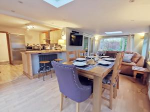 a kitchen and living room with a wooden table and chairs at Gilfach-3 Bed-Dog Friendly-Detached Bungalow in Trearddur