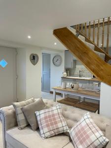 a living room with a couch and a staircase at Swallows Rest in Leek