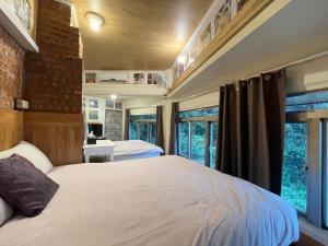a bedroom with a large bed and windows at Linyuan Village in Jiufen