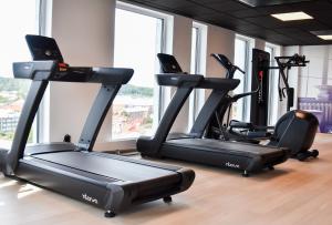 a gym with three tread machines in a room at ProfilHotels Halmstad Plaza in Halmstad