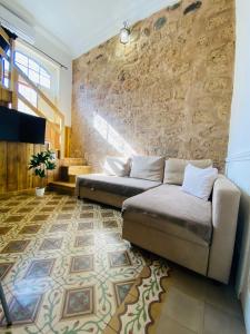 sala de estar con sofá y pared de piedra en Vacacionales Vegueta, en Las Palmas de Gran Canaria