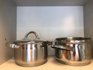 due pentole di metallo posizionate sopra un bancone della cucina di Lux Home на Амурской a Öskemen
