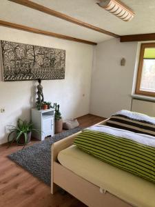 - une chambre avec un lit et une peinture murale dans l'établissement Ferienhaus Wieswald, à Ehrwald