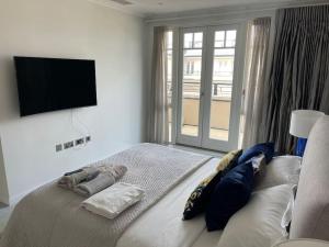 ロンドンにあるLarge luxury Penthouse with free parking garageのベッドルーム1室(大型ベッド1台、薄型テレビ付)