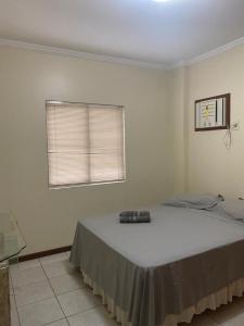 um quarto com uma cama com um controlo remoto em Otimo apartamento em Balneário Camboriu em Balneário Camboriú