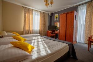 ダルウフコにあるTramontana Family & Wellnessのベッドルーム1室(黄色い枕とデスク付きのベッド2台付)