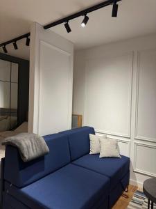 una sala de estar con un sofá azul en una habitación en Jahorina Apartman Benvenuti en Jahorina