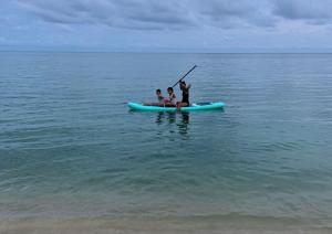 two people on a paddle board in the ocean at 4U Resort Samui in Lamai