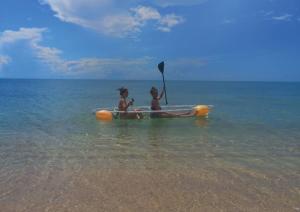two children are sitting in a paddle boat in the water at 4U Resort Samui in Lamai